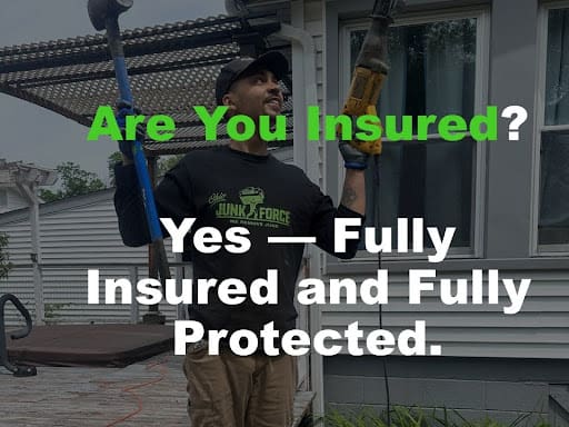 Ohio Junk Force crew member holding sledgehammer and power tool on porch, dressed in branded shirt and khakis; green overlay text confirms "Are You Insured? Yes—Fully Insured and Fully Protected" for safe junk removal.